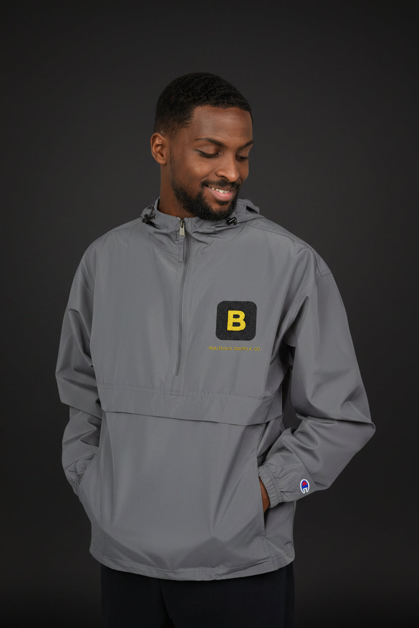 Man wearing a gray pullover with a logo on a white background