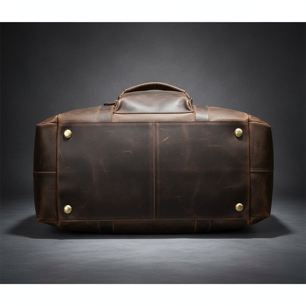 Brown leather duffel bag with gold rivets on a white background