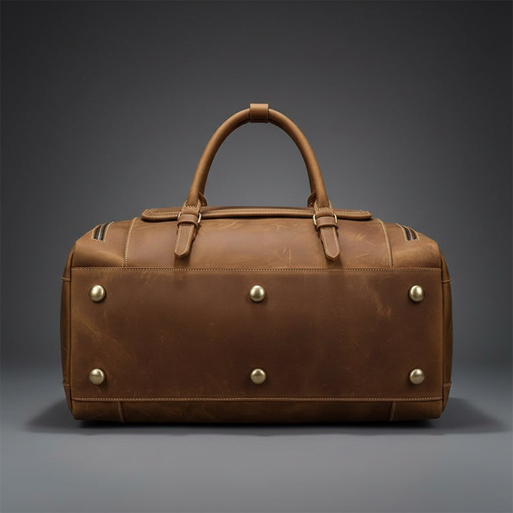 Brown leather duffel bag with silver studs on a white background
